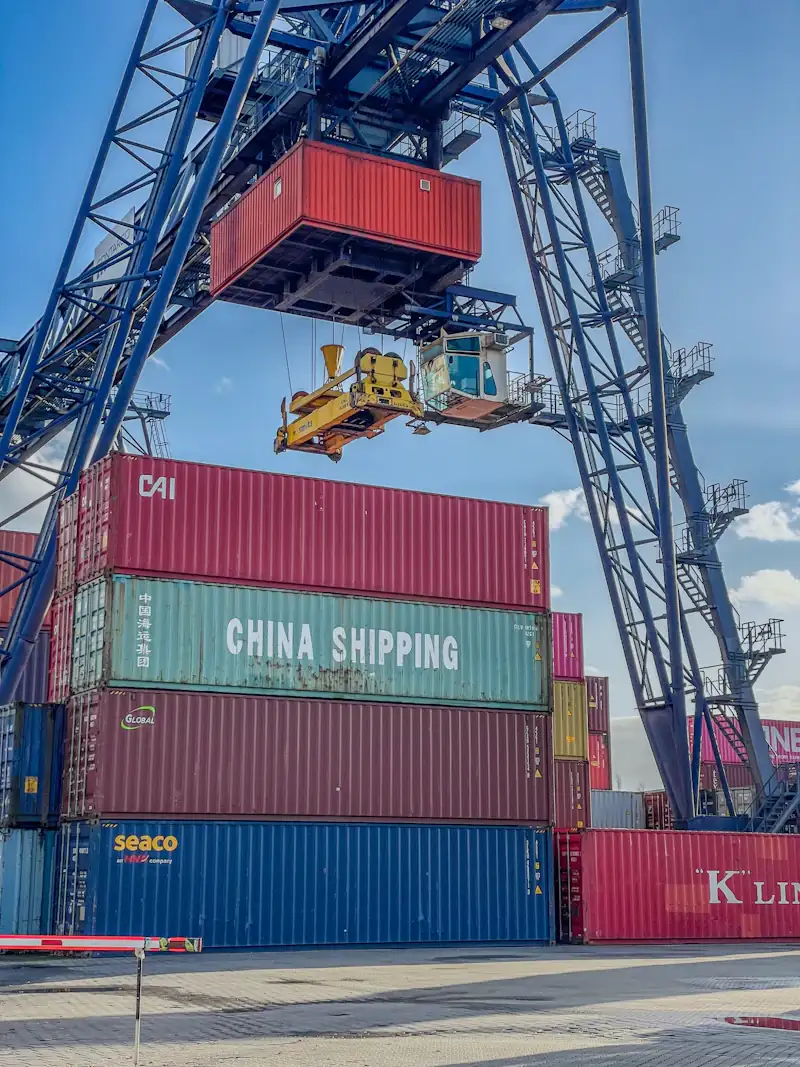 A gantry crane lifting a container above stacked China Shipping containers