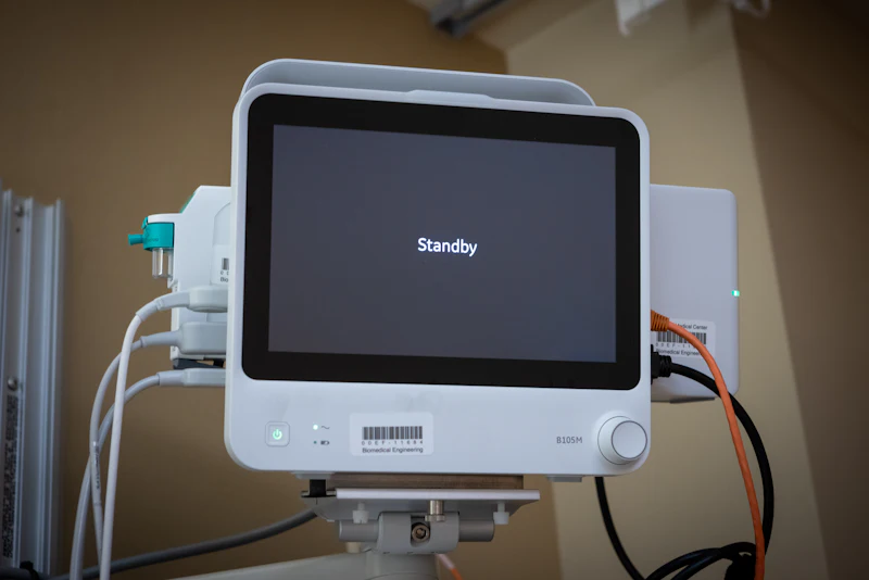 A patient monitor in standby with a biomedical engineering asset label