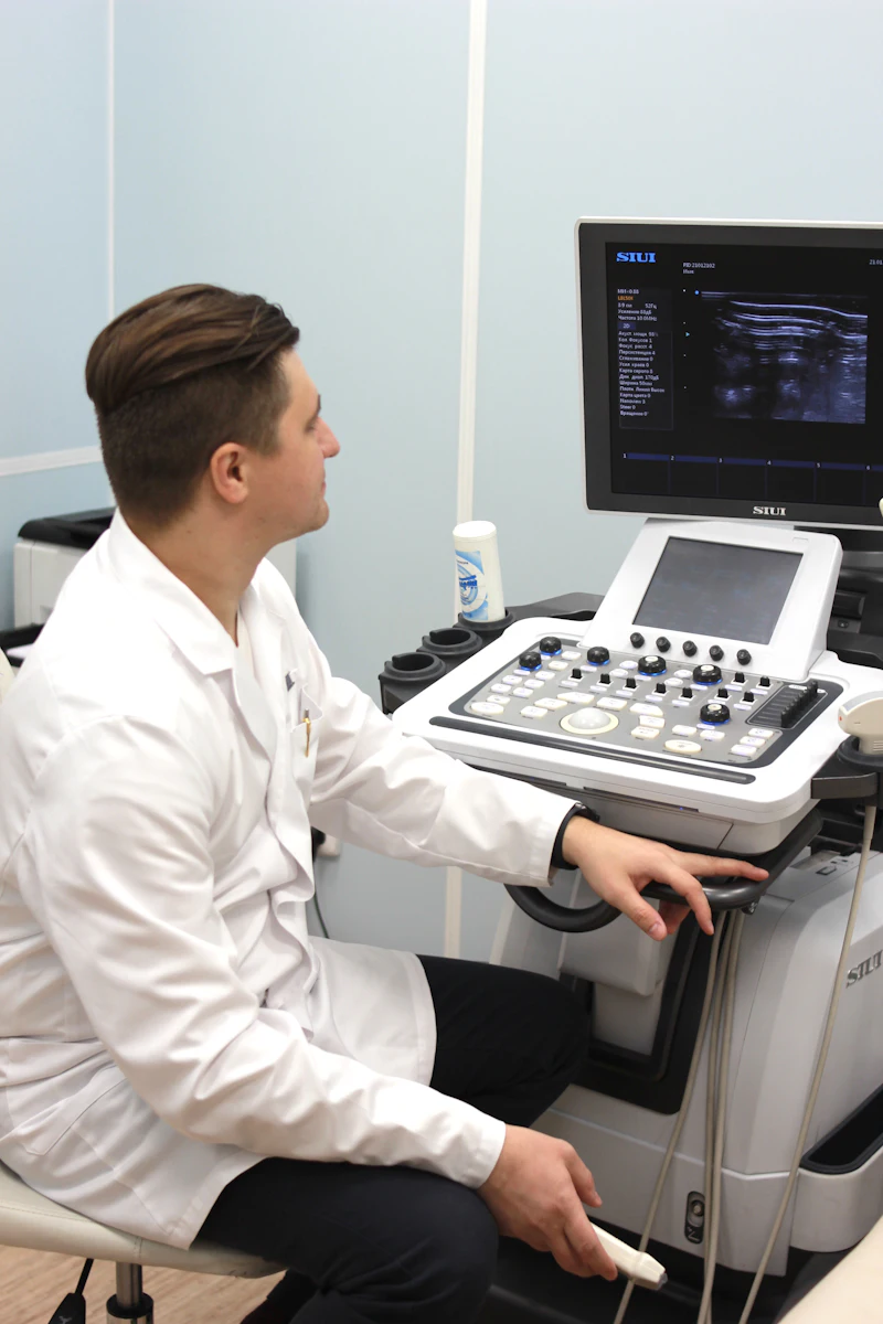 A clinician seated at an ultrasound system, mid-examination